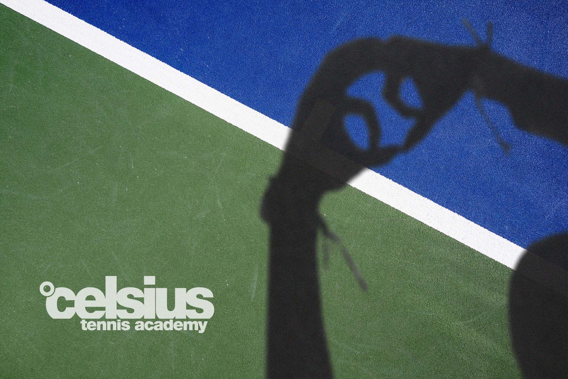 Shadow of a person on a multi-colored tennis court (green and blue) with a white boundary line; partial logo reading 'tennis academy' in the corner.